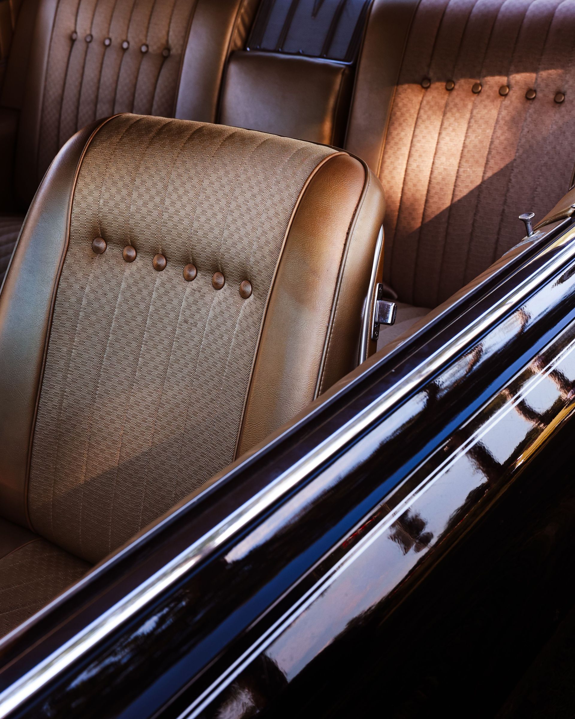 Close-up of a classic car's vintage interior featuring tan leather seats with retro design.